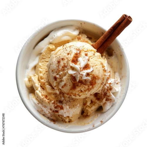 Vanilla ice cream scoops with whipped cream, cinnamon, and a cinnamon stick in a white paper cupl. photo