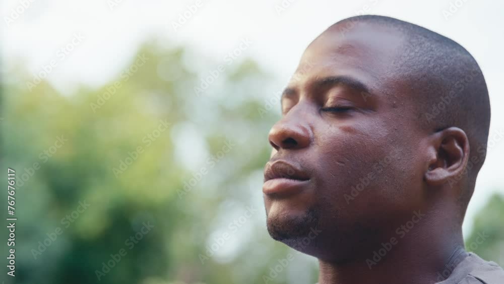 Portrait smiling man standing outdoors closing eyes and breathing deeply in countryside or garden - shot in slow motion