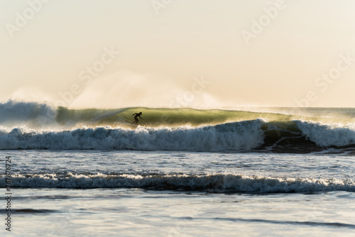 person inside the tube in the wave on the sea shore, high contrast photo