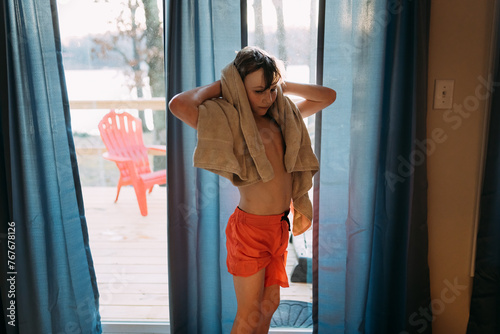 Child towel drying inside after swimming photo