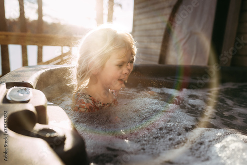 Kids in bubbly hot tub outdoors during vacation photo