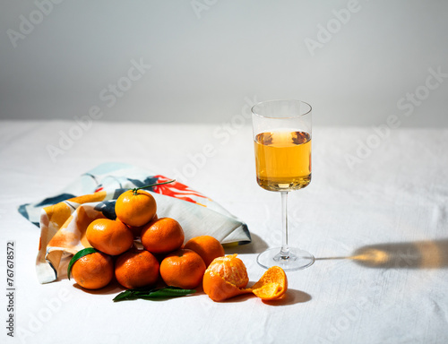 Vintage styled tall glass of natural orange wine next to stack o photo