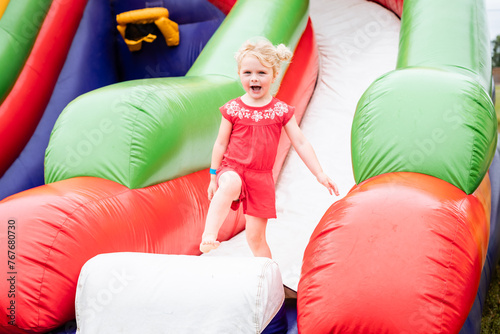 Happy child on inflatable bounce house at festival photo