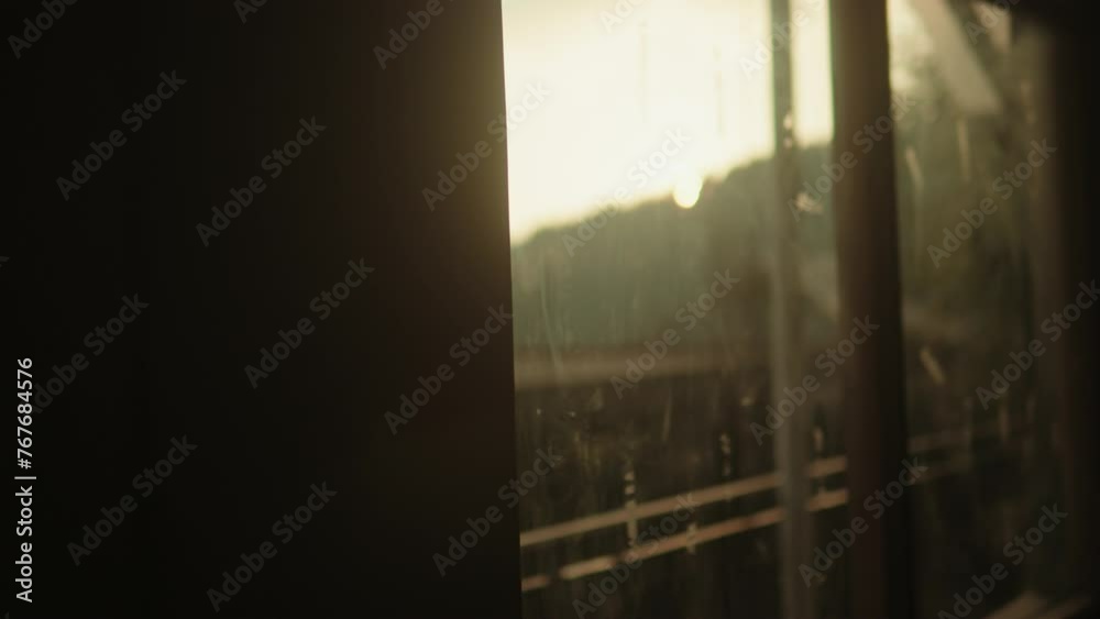 Sunset glow through a window, with a glimpse of tracks and poles, evoking travel nostalgia Sunset glow through a window, with a glimpse of tracks and poles, evoking travel nostalgia