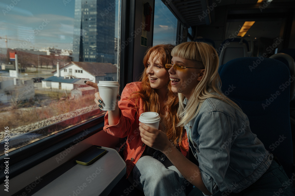 Two friends enjoying coffee and train ride