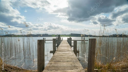 Wallpaper Mural Restless clouds move over a lake on a jetty. Sunrays break through the clouds, the storm is gathering. Torontodigital.ca