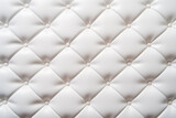 White leather upholstery. Close-up texture of genuine leather with white rhombic stitching.