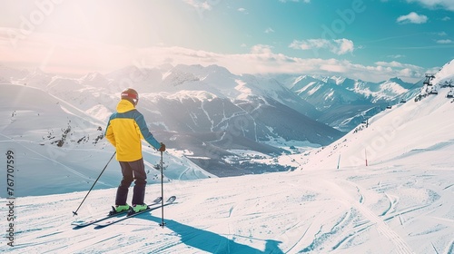 A skier is skiing down a mountain with a beautiful view of the surrounding landscape. The skier is wearing a yellow jacket and is holding ski poles. The scene is peaceful and serene