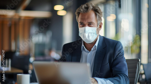 businessman wearing surgical mask and working with laptop in the office