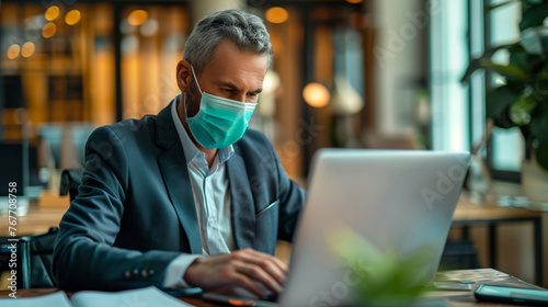 businessman wearing surgical mask and working with laptop in the office