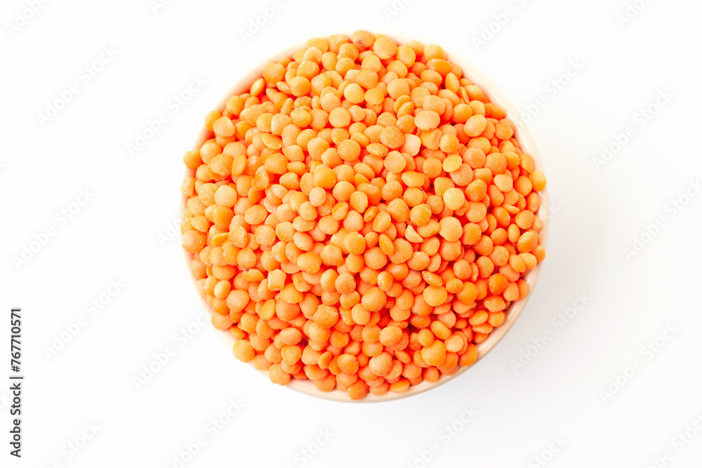 Uncooked red lentils in bowl on white background. Dry orange lentil grains. Top view Uncooked red lentils in bowl on white background. Dry orange lentil grains. Top view