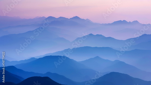 Tranquil Dawn Breaking Over Misty Mountain Ranges with Layers of Blue and Purple Hues