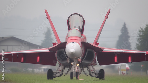 A red fighter jet sits on a foggy runway