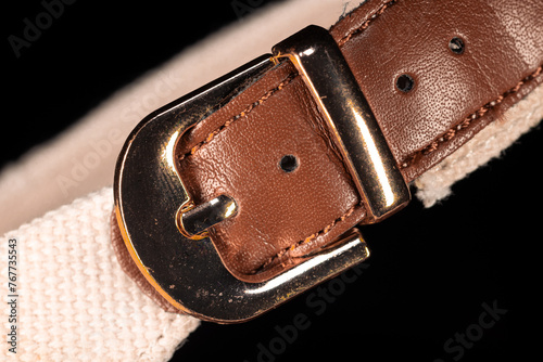 Brown vintage leather strap with buckle. Brown leather belt with buttoned steel buckle closeup