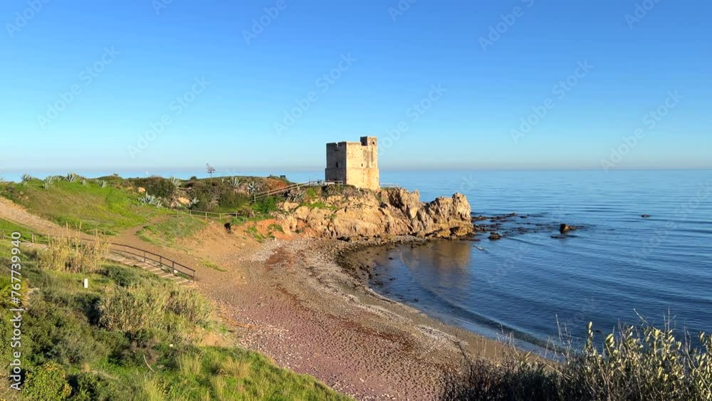Torre de la Sal in Casares Manilva beach in Spain, coastal tower system for surveillance and defence against Berber pirates, green plants at the sunny beach, 4K shot Torre de la Sal in Casares Manilva beach in Spain, coastal tower system for surveillance and defence against Berber pirates, green plants at the sunny beach, 4K shot