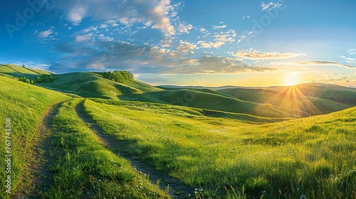 Picturesque winding path through a green grass field in hilly area in morning