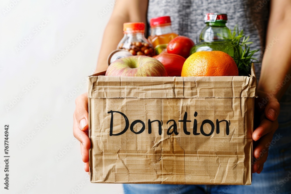 © itchaznong - Donation concept. A woman is holding a box of vegetables © itchaznong - Donation concept. A woman is holding a box of vegetables
