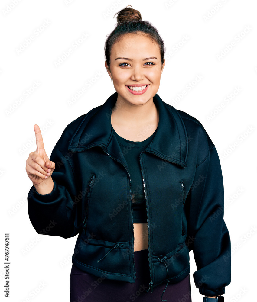 Young hispanic girl wearing sportswear showing and pointing up with finger number one while smiling confident and happy. Young hispanic girl wearing sportswear showing and pointing up with finger number one while smiling confident and happy.