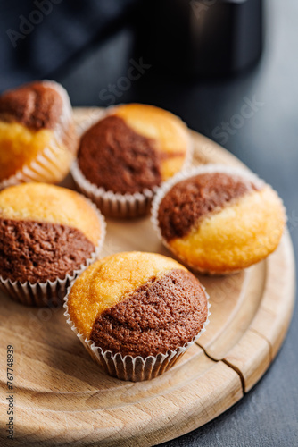 Close Up of a Muffins on cutting board on black table.