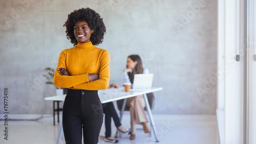 Close up of beautiful young smiling professional black african business woman, coworkers hold a meeting in background. Portrait of beautiful confident smiling african-american businesswoman