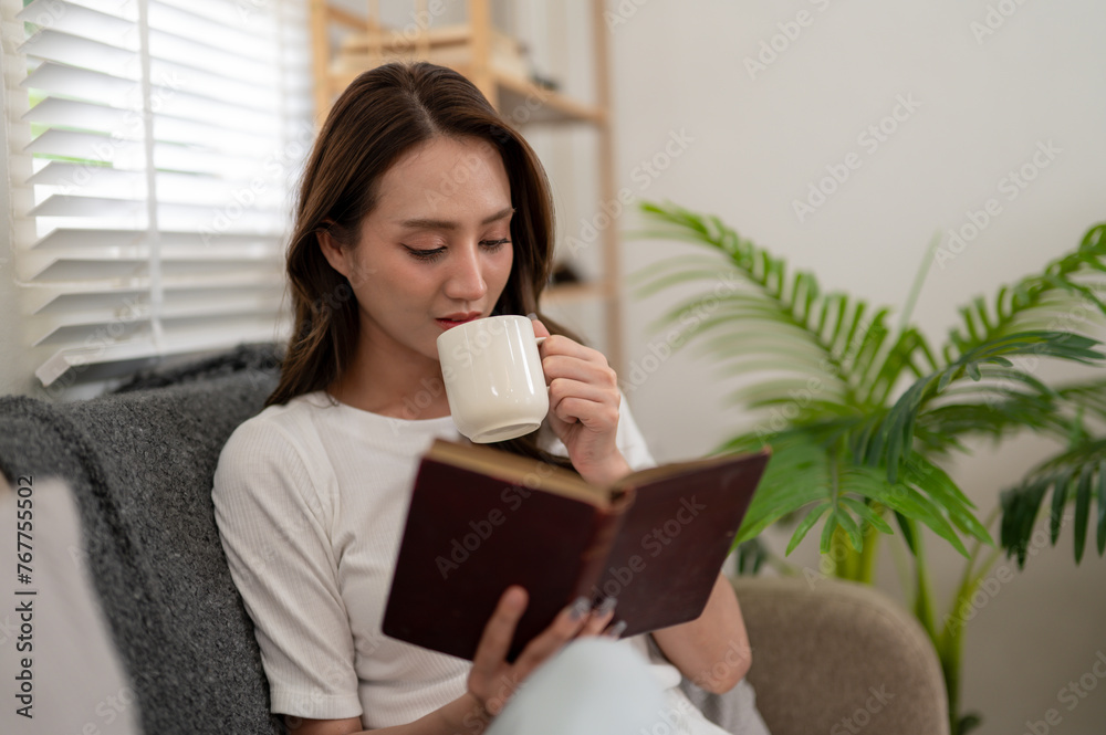 Young woman enjoying reading a book, Sipping coffee on the sofa at home. Young woman enjoying reading a book, Sipping coffee on the sofa at home.
