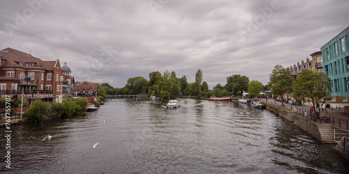 Panorama of the River Thames and Romney Island in Windsor England with buildings on the banks, boats in the water and a bird flying in the foreground