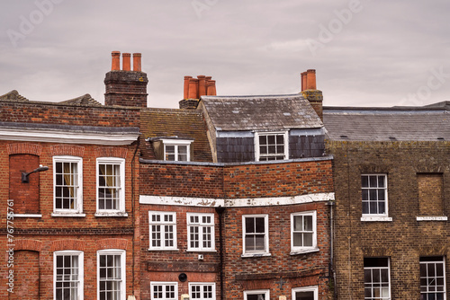 close up of top stories of ancient crooked brick buildings in Windsor England showing different windows and different age buiildings