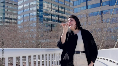 Curvy woman talking on phone while walking in the city.