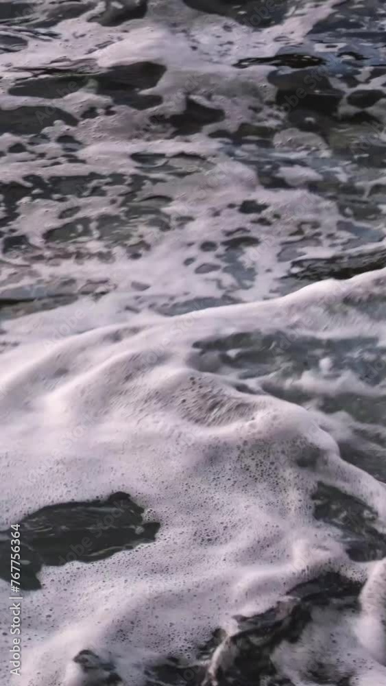 Abstract slow motion blue and grey waves with white foam swirling and splashing on the beach. Waves crashing on the Adriatic Sea coastline. Close-up of continuously changing disquiet sea surface. Abstract slow motion blue and grey waves with white foam swirling and splashing on the beach. Waves crashing on the Adriatic Sea coastline. Close-up of continuously changing disquiet sea surface.