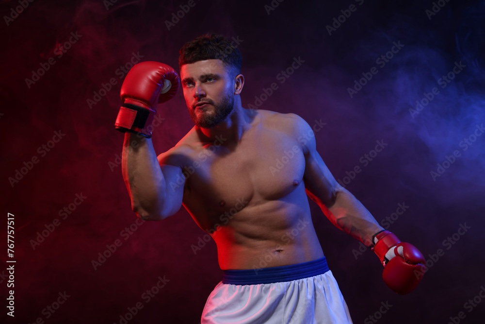 Man wearing boxing gloves fighting on dark background Man wearing boxing gloves fighting on dark background