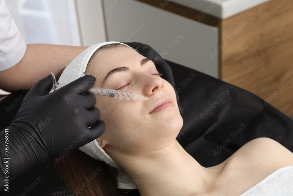 Cosmetologist giving lips injection to patient in clinic, closeup. Cosmetic surgery Cosmetologist giving lips injection to patient in clinic, closeup. Cosmetic surgery