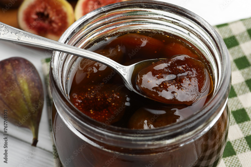 Jar of tasty sweet fig jam on white table, closeup Jar of tasty sweet fig jam on white table, closeup