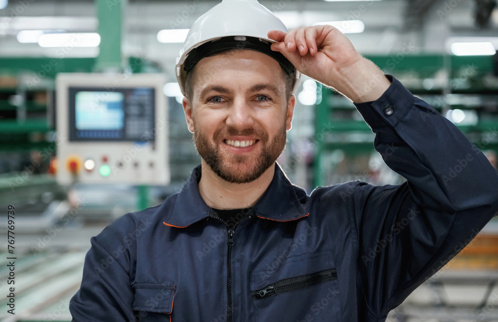 In white hard hat. Factory worker is indoors In white hard hat. Factory worker is indoors