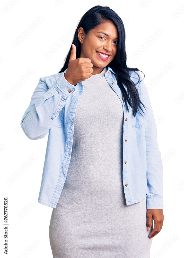 Hispanic woman with long hair wearing casual denim jacket doing happy thumbs up gesture with hand. approving expression looking at the camera showing success. Hispanic woman with long hair wearing casual denim jacket doing happy thumbs up gesture with hand. approving expression looking at the camera showing success.
