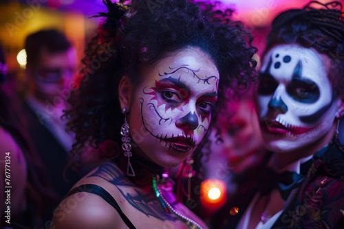 Two people with elaborate face paint and makeup, dressed in costumes, are posing for the camera at a lively Halloween party