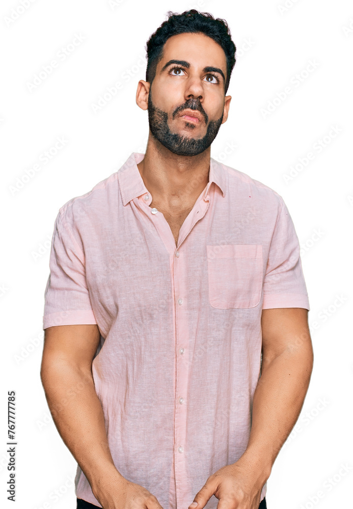 Hispanic man with beard wearing casual shirt making fish face with lips, crazy and comical gesture. funny expression. Hispanic man with beard wearing casual shirt making fish face with lips, crazy and comical gesture. funny expression.