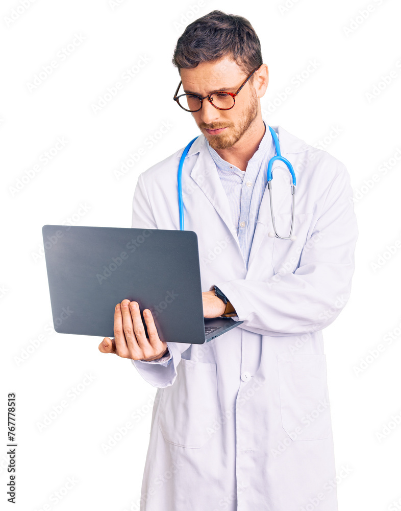 Handsome young man with bear wearing doctor uniform working using computer laptop thinking attitude and sober expression looking self confident Handsome young man with bear wearing doctor uniform working using computer laptop thinking attitude and sober expression looking self confident