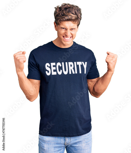 Young handsome man wearing security t shirt very happy and excited doing winner gesture with arms raised, smiling and screaming for success. celebration concept.
