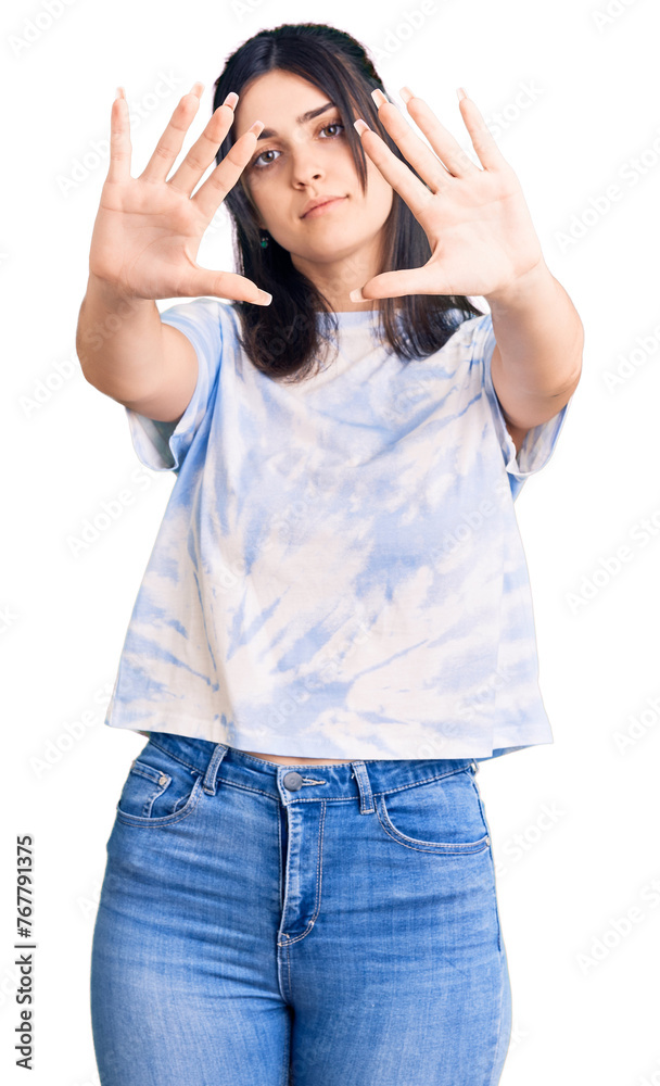 Young beautiful girl wearing casual t shirt doing frame using hands palms and fingers, camera perspective Young beautiful girl wearing casual t shirt doing frame using hands palms and fingers, camera perspective