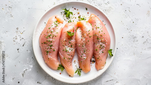 Raw chicken breasts seasoned with herbs, ready for cooking.