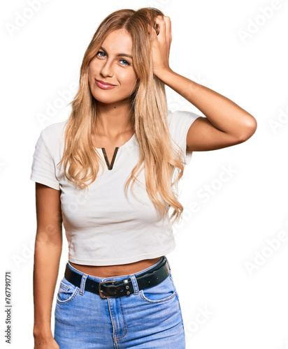 Beautiful blonde young woman wearing casual white tshirt confuse and wonder about question. uncertain with doubt, thinking with hand on head. pensive concept.
