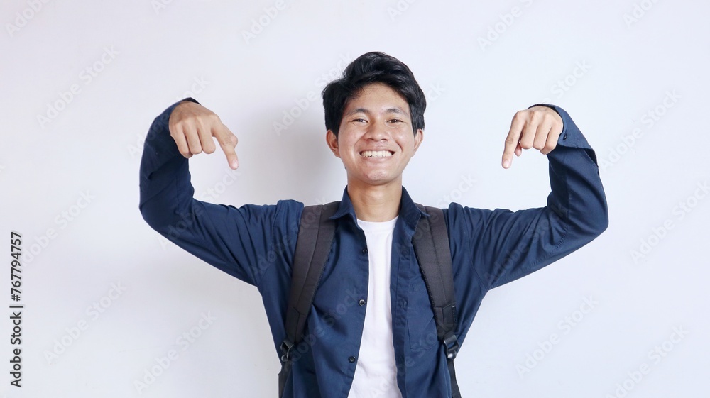 Young handsome Asian male enthusiastic student gesturing pointing down Young handsome Asian male enthusiastic student gesturing pointing down