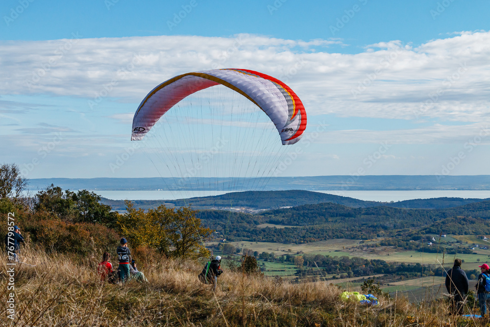Paragliding on the mountainside, a lake in the distance. Paragliding on the mountainside, a lake in the distance.
