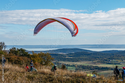 Paragliding on the mountainside, a lake in the distance.