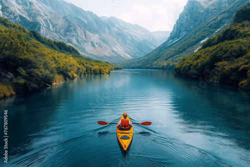 woman kayaker is sailing on yellow kayak on river on summer trip in tropics with landscape with mountains and forest © alexkoral