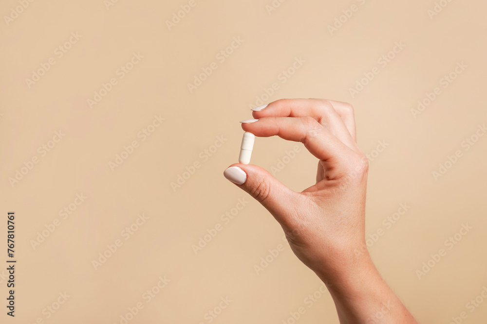 Ταπετσαρία White pill in female hand on beige background, Taking Your Medication