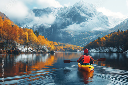 male kayaker kayaking on lake in autumn with a landscape of mountains and forests in the snow © alexkoral