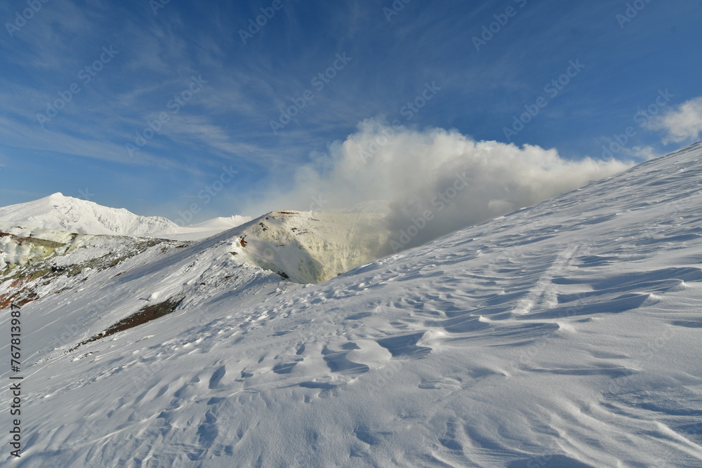 Smoke rising from winter landscape snow-capped Mt. Tokachi volcano, Hokkaido, Japan