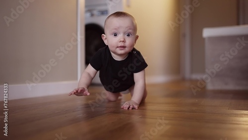 baby learns to crawl on the floor at home. happy family kindergarten kids concept. First steps, baby crawling front view . baby learns to crawl to explore the world around dream him