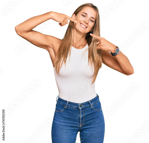 Young blonde woman wearing casual style with sleeveless shirt smiling cheerful showing and pointing with fingers teeth and mouth. dental health concept.